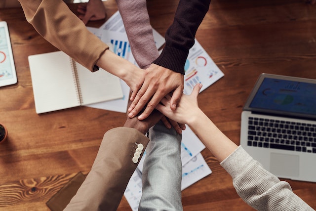 group of people putting their hands in for a corporate team huddle