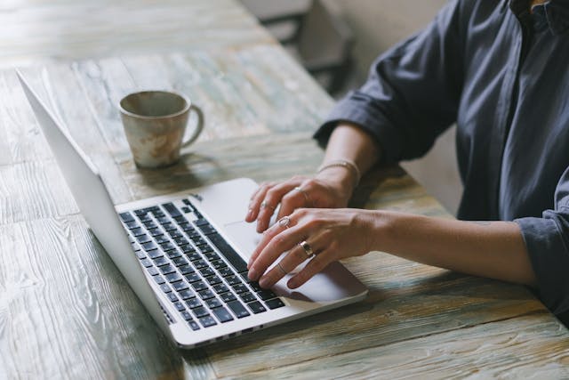 person working in a laptop with a coffee