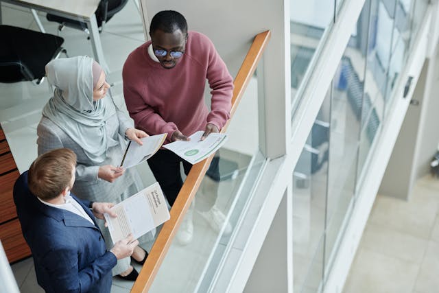 three people discussing document