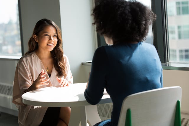 two people sitting at a table having a conversation